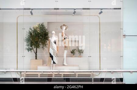 Fenstervitrine im Laden mit Manequins, die neue Kleidung zeigen Stockfoto