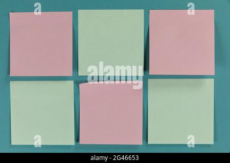 Ansicht von sechs grünen und rosa Blatt Papier in Eine Größe auf einfarbigem blauem Hintergrund Stockfoto