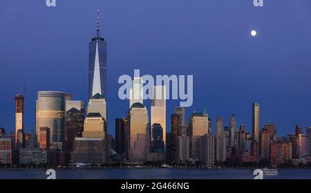 Vollmond, der zur Blauen Stunde über Lower Manhattan aufsteigt Stockfoto