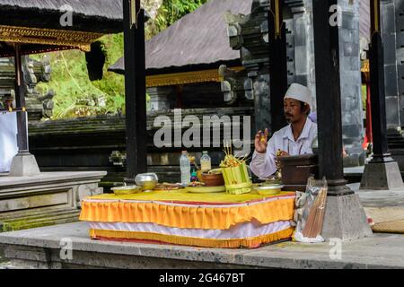 Hindu-Priester, der eine Puja im Gunung Kawi-Tempel und Grabkomplex in der Nähe von Tpaksiring Village, Bali, Gianyar Regency, Indonesien, aufführt Stockfoto