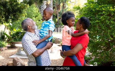 Ältere afroamerikanische Paar Zeit in ihrem Enkel und Enkelin im Garten Stockfoto