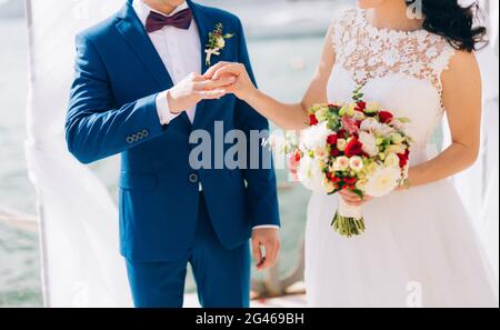 Die Braut steckt den Ring an den Bräutigam bei der Hochzeit ceremon Stockfoto