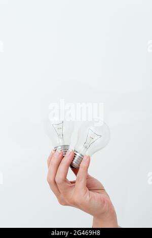 Frau Hände Halten Lampe Präsentiert Ideen Für Projekt, Mann Palm Zeigt Glühbirnen Und Neue Technologien, Zwei Held Glühbirnen Exhibiti Stockfoto