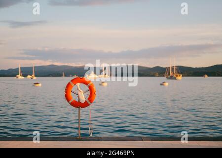 Rettungsring in der Marina für Yachten. Roter Kreis auf dem Bootssteg. Stockfoto