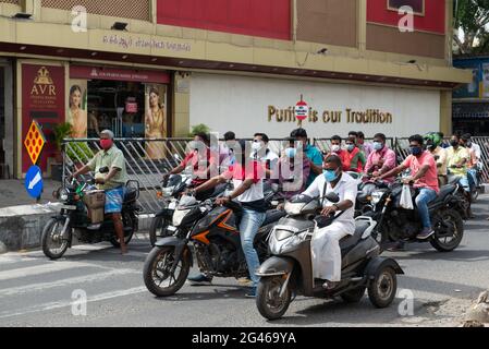 PONDICHERRY, INDIEN - Juni 2021: Alle tragen eine Maske, niemand trägt einen Helm in der Anna Salai Road. Stockfoto