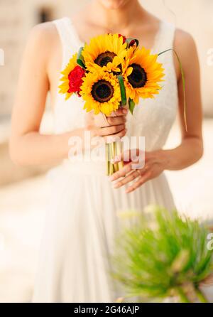 Hochzeit Brautstrauß von Sonnenblumen in den Händen der Braut. Stockfoto