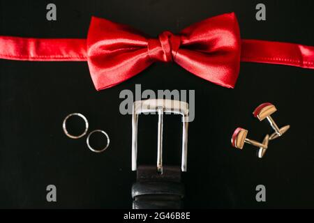 Schwarze Schuhe für den Bräutigam, rote Fliege, Manschettenknöpfe, Riemen, auf ein bla Stockfoto