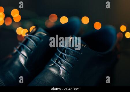 Schwarze Schuhe mit Schnürsenkeln Mannes. Gegen Hintergrund Bokeh. Stockfoto