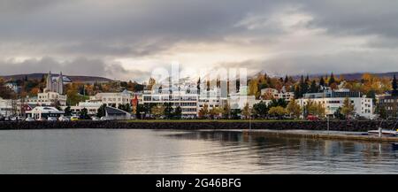 Ein Blick auf die Stadt Akureyri, als der Schneeberg aus der bedrohlichen Wolke im Hintergrund enthüllt wurde Stockfoto