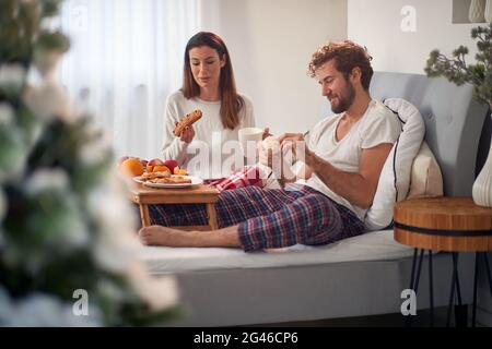 Junges erwachsenes Paar beim Frühstück im Bett Stockfoto