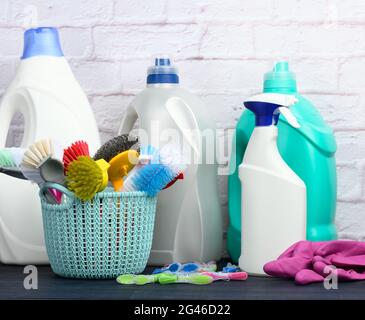 Blauer Kunststoffkorb mit Bürsten, Schwämmen und Gummihandschuhen zur Reinigung Stockfoto