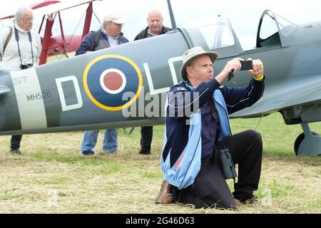 Turweston Airfield, Buckinghamshire, Großbritannien - Samstag, 19. Juni 2021 - Piloten und Luftfahrtbegeisterte haben heute an einem bewölkten Sommertag die Möglichkeit, am Air Britain Fly-in auf dem Turweston Airfield teilzunehmen. Das Foto zeigt einen Luftfahrtbegeisterten, der ein Foto mit einer Replik Spitfire im Hintergrund macht. Foto Steven May / Alamy Live News Stockfoto