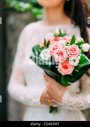 Brautstrauß aus rosa Rosen in den Händen der Braut. Hochzeit in Monte Stockfoto