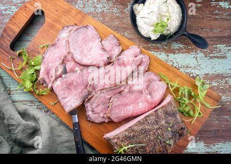 Traditionelles Mittagsfleisch im modernen Stil mit Aufschnitt, Roastbeef mit Rucola und Remoulade, die als Draufsicht auf einem Arbeitsauftrag angeboten wird Stockfoto