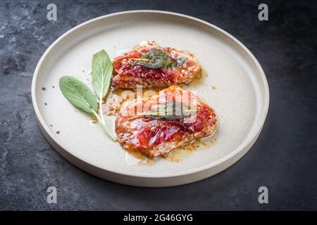 Traditionelle italienische Saltimbocca alla Romana mit Parmaschinken und Salbeiblättern in modernem Stil, die als Nahaufnahme in einem Nord angeboten werden Stockfoto