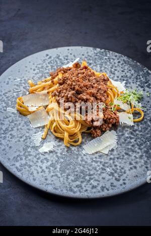 Traditionelle italienische Ragu alla Bolognese-Sauce im modernen Stil mit Linguinnudeln und Parmesankäse, die als Nahaufnahme serviert werden Stockfoto
