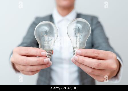 Dame Mit Zwei Glühbirnen In Den Händen Und Formellem Outfit Präsentiert Eine Weitere Ideen Für Project, Business Woman Holding 2 Lampen Sh Stockfoto
