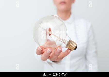 Lady Holding Lampe Mit Formellem Outfit Präsentiert Neue Ideen Für Das Projekt, Business Frau Zeigt Glühlampe Mit Einer Hand Ausstellen Neu Stockfoto