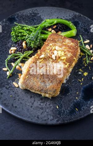 Traditionelles, in der Pfanne gebratenes Kabeljaufischfilet in Paniermehl mit Baby-Brokkoli Stockfoto