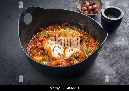 Moderne traditionelle langsam gekochte italienische Kalbsrouladen Saltimbocca mit Gemüse und Oliven in würziger Soße als close-U Stockfoto