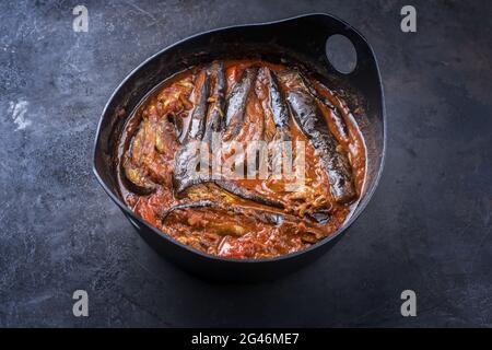 Modern-Stil langsam gekocht persischen Lamm Aubergine Eintopf khoresh bademjan serviert als close-up in einem Design-Topf auf einem rustikalen Brett mit c Stockfoto