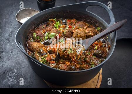 Traditionelle, langsam gekochte amerikanische Tex-Mex-Fleischbällchen mit Auberginen und Hackbraten in einer würzigen Sauce, die als Nahaufnahme in einem Design angeboten werden Stockfoto