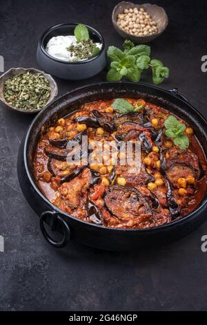 Im modernen Stil langsam gekochte libanesische vegetarische Auberginen-Eintopf-Maghmour, serviert mit Kichererbsen als Nahaufnahme in einem Design-Topf Stockfoto