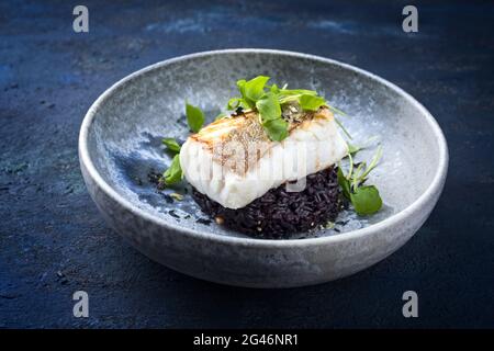 Traditionelles, gebratenes Kabeljaufischfilet in modernem Stil mit portulaca-Salat Stockfoto