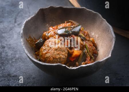 Traditionelle, langsam gekochte amerikanische Tex-Mex-Fleischbällchen mit Auberginen und Hackbraten in einer würzigen Sauce, die als Nahaufnahme in einem rustikalen Restaurant angeboten wird Stockfoto