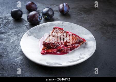 Französische Pflaumen im modernen Stil mit süßen Pflaumen und Vanille, die als Nahaufnahme auf einer Designplatte angeboten werden Stockfoto