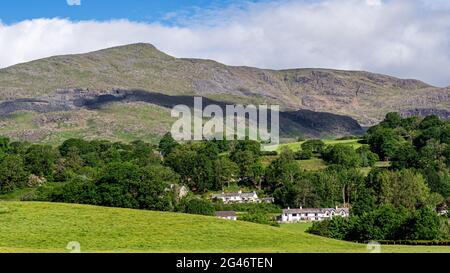 Das Dorf Coniston und der alte Mann von Coniston mit seinen vielen Schieferminen und seinen Abbaustätten an seinen Hängen im Frühsommer im Lake District Stockfoto