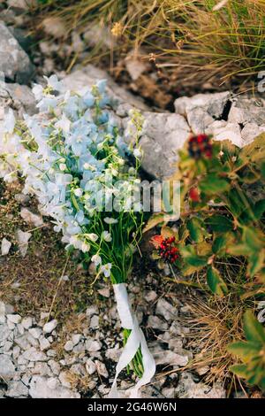 Hochzeit Brautstrauß der blauen Delphinium auf den Felsen. Hochzeit Stockfoto