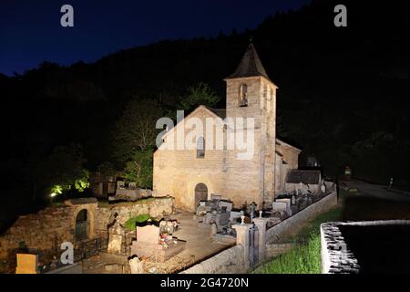 Kirche, Teil eines ehemaligen Klosters, das nachts beleuchtet wurde, im spektakulären abgelegenen Dorf St. Chely du Tarn, Lozere, Frankreich. Die Schluchten des Tarn und des Jonte und die Grands Causses gehören zu den besten Standorten Okzitaniens, die bald zur Grand Site von Frankreich gehören werden Stockfoto