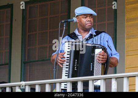 NEW ORLEANS, LA, USA - 11. JUNI 2021: Bruce 'Sunpie' Barnes spielt Akkordeon während eines Front Porch Konzerts in Uptown Nachbarschaft Stockfoto