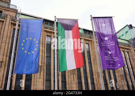 Verschiedene Flaggen in der Düsseldorfer Innenstadt (EU-Flagge, Nordrhein-westfälische Flagge, Werbeflagge) mit Kaufhof Kaufhaus im Hintergrund. Stockfoto