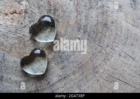 Zwei transparente Herzen auf die raue Oberfläche des ein alter Baumstumpf. Perfekte Valentinstag Grußkarte Hintergrund. Stockfoto