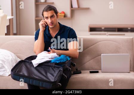 Junger Mann, der sich zu Hause auf die Reise vorbereitet Stockfoto