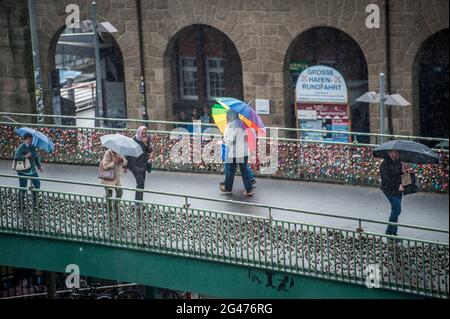 Regen in Hamburg. Fußgängerbrücke mit Passanten und Regenschirmchen an den Landungsbrücken. Stockfoto