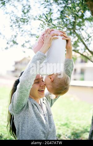 Lächelnde Mutter hält ihr kleines Mädchen auf den Kopf Stockfoto