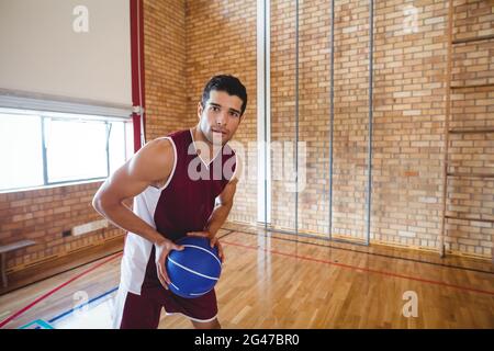 Basketballspieler hält Basketball auf dem Platz Stockfoto