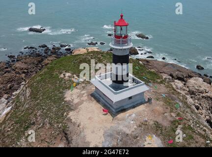 Quanzhou. Juni 2021. Luftaufnahme vom 19. Juni 2021 zeigt den Leuchtturm von Chidingyu in Quanzhou, südöstlich der Provinz Fujian in China. Der Leuchtturm Chidingyu, der sich am Wendepunkt der inneren Route auf der Westseite der Straße von Taiwan befindet, wurde am Samstag offiziell in Betrieb genommen. Es wird von grüner Energie angetrieben und deckt einen Lichtbereich von mehr als 15 Seemeilen ab. Der Leuchtturm ist mit modernen Navigationsgeräten ausgestattet, die den Bedürfnissen verschiedener Arten von Schiffen in und aus der Bucht von Quanzhou gerecht werden. Quelle: Wei Peiquan/Xinhua/Alamy Live News Stockfoto