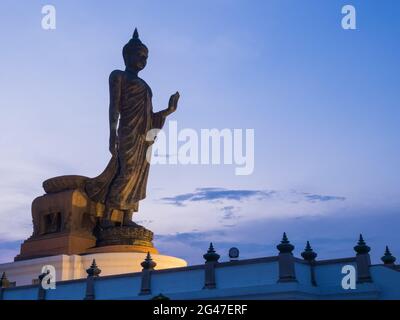 Grand Walking buddha Bronzestatue ist die Hauptstatue in Phutthamonthon (buddhistische Provinz) in Nakornpathom, Thailand, in der Dämmerung Stockfoto