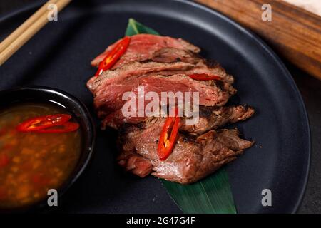 Rindfleisch-Tataki auf heißem Salz mit Sauce serviert Stockfoto