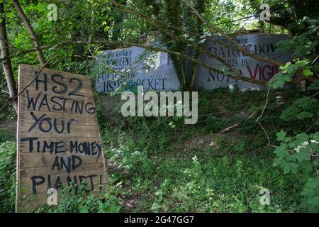 Wendover, Großbritannien. Juni 2021. Neben der A413 sind vor dem Wedover Active Resistance Camp von Stop HS2 lackierte Schilder abgebildet. Große Landflächen rund um Wendover im Chilterns AONB wurden für das HS2-Eisenbahninfrastrukturprojekt bereits von Bäumen und Vegetation freigeräumt, trotz des konzertierten Widerstands von Anwohnern und Umweltaktivisten. Kredit: Mark Kerrison/Alamy Live Nachrichten Stockfoto