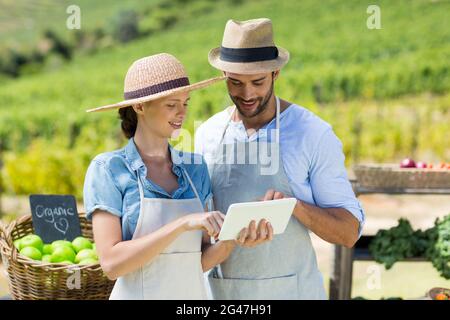 Glückliches Paar mit digitalen Tablet auf dem Bauernhof Stockfoto