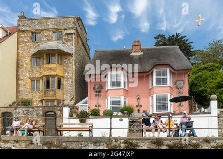 Sundial House und ein malerisches rosafarbenes Ferienhaus auf der Marine Parade in Lyme Regis, Dorset, England, Großbritannien Stockfoto