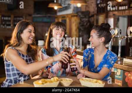 Glückliche Freundinnen mit Bierflaschen zum Toasten Stockfoto