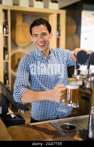 Bar Tender Befüllung Bier aus Bierpumpe Stockfoto