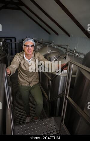 Porträt eines Arbeiters, der an Lagertanks auf einer Treppe steht Stockfoto