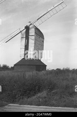1954, historisch, Windmühle, Essex, England, VEREINIGTES KÖNIGREICH. Diese markanten Gebäude, die in verschiedenen Formen erhältlich sind, haben Klingen oder Flügel, einige davon auf Holzkonstruktionen, die hier zu sehen sind, über einem Stein- oder Ziegelgebäude, das den Strom aus dem Wind erzeugt, um Mais zu Mehl zu mahlen. Stockfoto